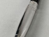 a close up of a pen on a white surface with a black tip