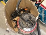 une caisse remplie d'outils posée par terre dans le garage
