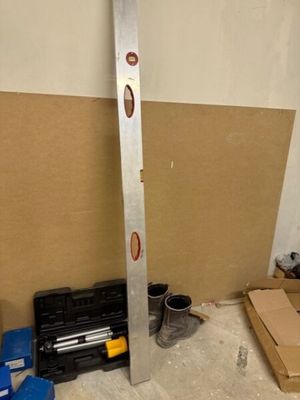 une photo d'une pièce où l'on voit une boîte à outils et des outils posés par terre