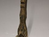 bronze statue of a foot with a bird ' s head on it