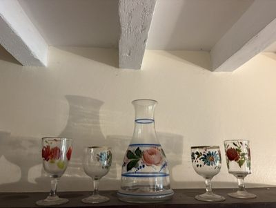 Des bouteilles et des verres sont posés sur une étagère dans une pièce.