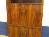 une armoire en bois dont la porte est ouverte et repose sur le sol