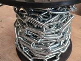 une bobine de chaînes et des chaînes posées sur une table