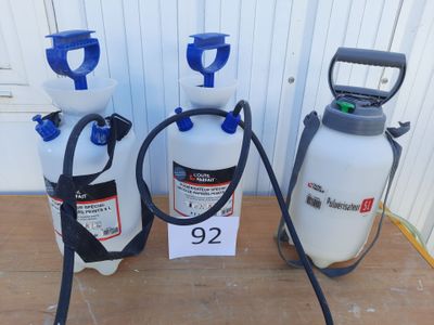 trois vaporisateurs et un tuyau d'arrosage sont posés sur une table