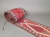 un rouleau de tissu posé par terre à côté d'un rouleau de moquette