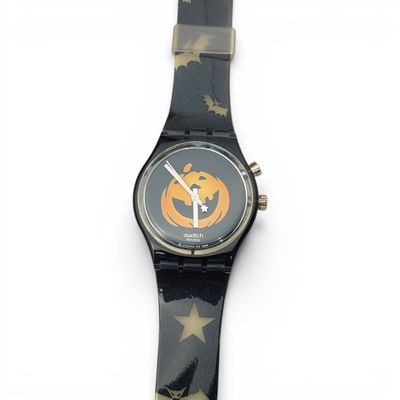 a black watch with a pumpkin on it on a white surface