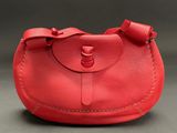 a red purse with a bow on the handle