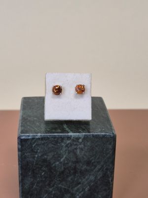 une photo d'une paire de boucles d'oreilles posée sur un bloc de marbre