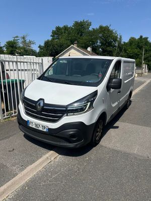 a white van parked on the side of a road next to a fence