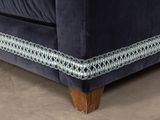 close up of a blue velvet couch with a silver trim