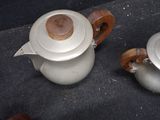 two teapots that are sitting on the ground