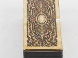 a small box with a gold and black design on it