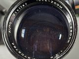 a close up of a camera lens with a cell phone in the background