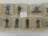 de nombreuses figurines de soldats disposées dans des boîtes en plastique sur une table