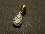 a close up of a gold and silver pendant on a black surface