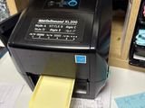 a printer sitting on top of a desk with a yellow paper