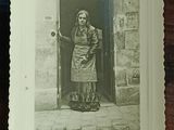 a black and white photo of a woman standing in front of a door