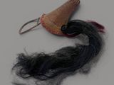 une image représentant une barrette avec une longue mèche de cheveux noirs