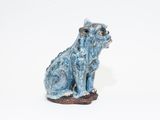 a small statue of a dog sitting on a white surface
