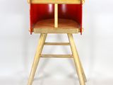 une chaise haute rouge avec un siège en bois sur fond blanc