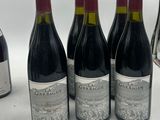 three bottles of red wine are lined up on a table