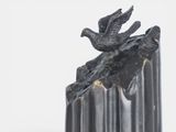 a sculpture of a bird on a rock on a white background