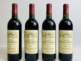 three bottles of red wine are lined up on a white surface