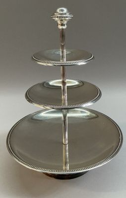 une photo d'un présentoir à gâteaux à trois étages surmonté d'une assiette en argent