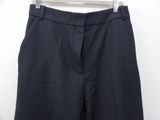 black pants hanging on a hanger on a white wall