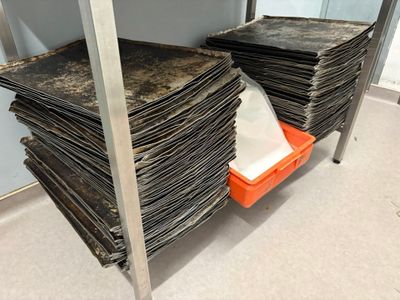 many stacks of papers stacked on a shelf in a room