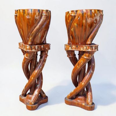 two vases that are made of wood and have twisted stems