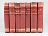 six livres rouges alignés en rangées sur une surface blanche