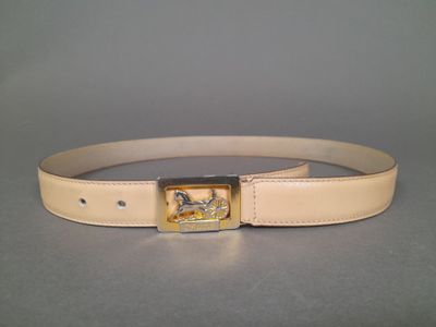 beige leather belt with a gold buckle with a horse on it