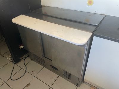 une image d'une cuisine avec un évier et un réfrigérateur
