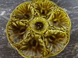 a yellow plate with a flower on it on a table