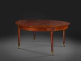 une table ovale en acajou avec des pieds en laiton