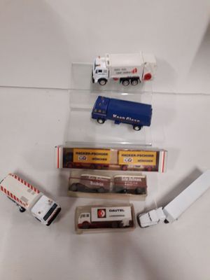 several toy trucks are lined up on a white surface