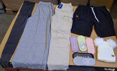 several pairs of pants, mittens, and shoes are laid out on a table