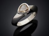 a close up of a ring with a white diamond on it
