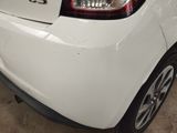 the rear end of a white car with a red light on