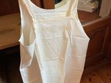 a white tank top on a hanger in a room