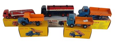 plusieurs camions jouets sont alignés sur une surface blanche