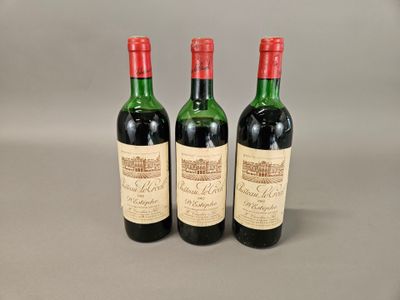 trois bouteilles de vin posées sur une table l'une à côté de l'autre