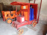 un petit chariot rouge avec une boîte bleue à l'arrière