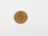 a close up of a gold coin on a white surface
