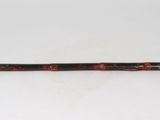 an old wooden stick with a wooden handle on a white surface