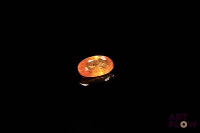 un gros plan sur un diamant orange dans l'obscurité
