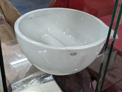 un bol blanc posé sur une étagère en verre dans un magasin