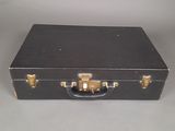 a black suitcase with gold handles on a white surface
