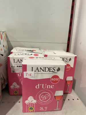deux cartons de vin posés sur un comptoir, à côté d'une bouteille